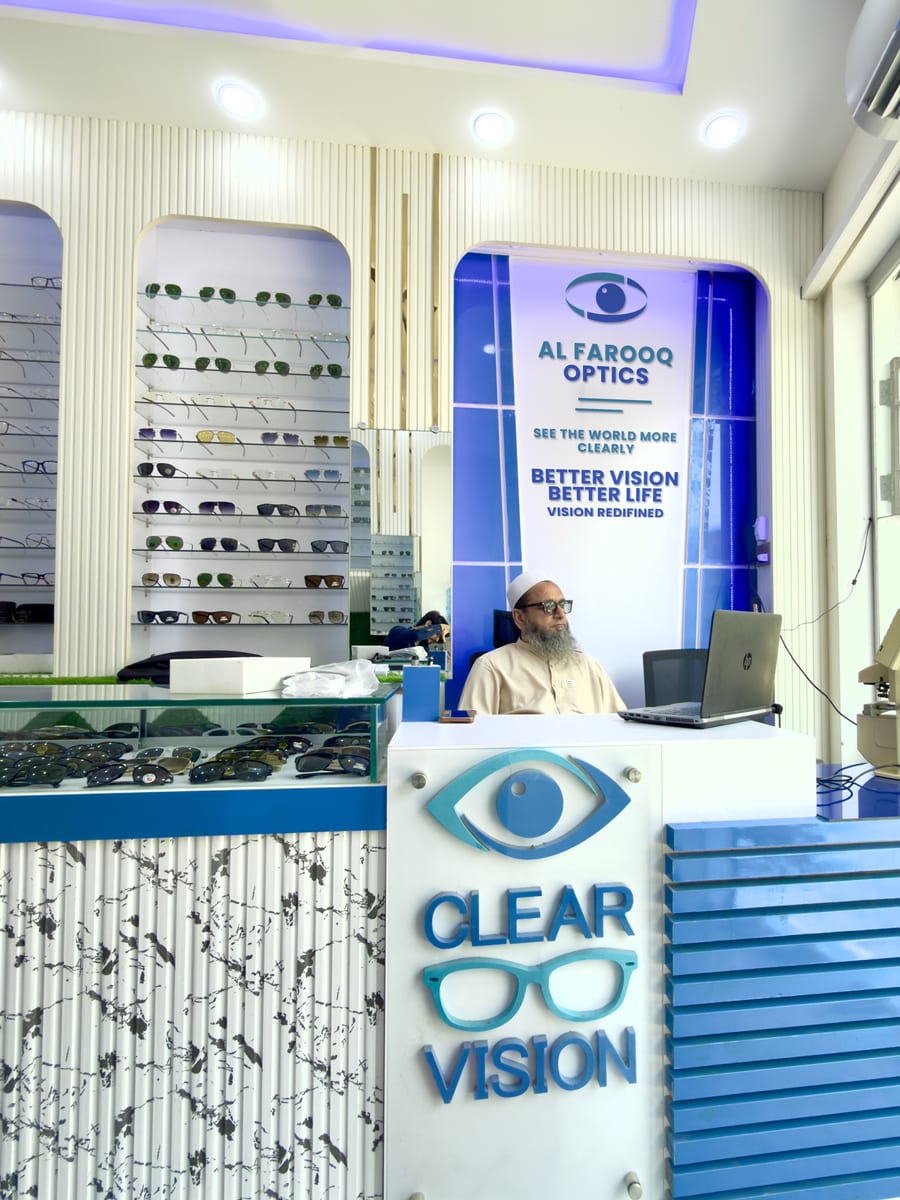 Inside Al Farooq Optics on Railway Road, Pasrur — frames on the wall and the counter